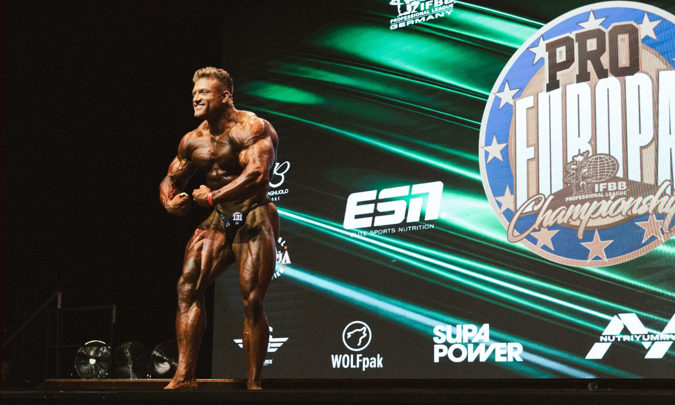 Urs Kalecinski auf der Bühne der Men’s Open Bodybuilding Klasse – voller Fokus, Symmetrie und Muskelaufbau