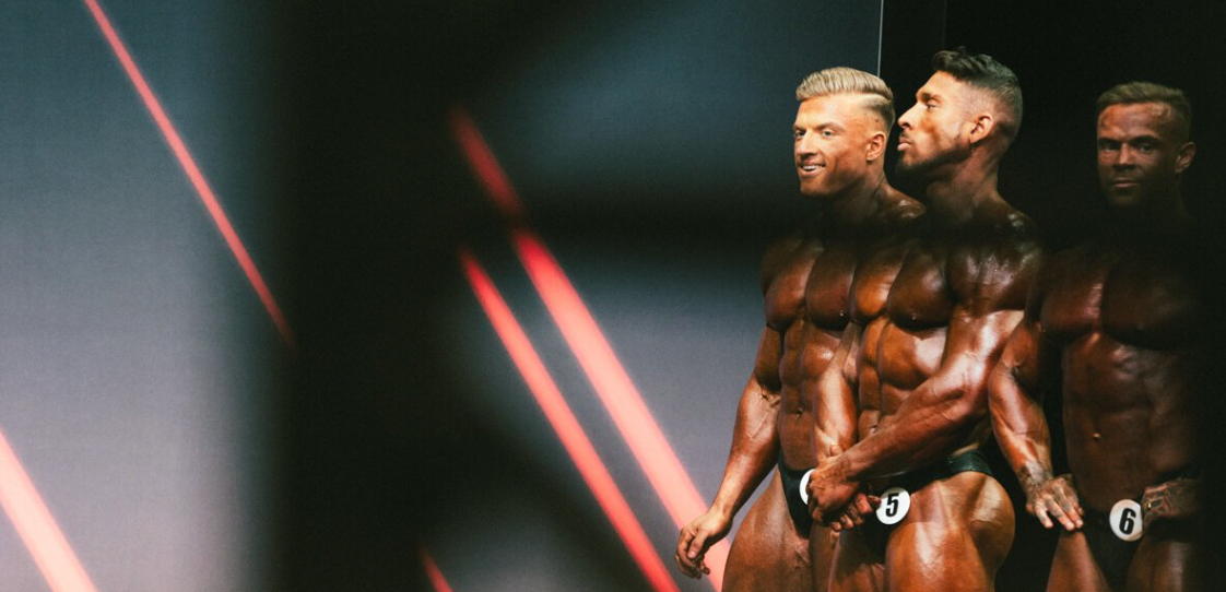 Urs Kalecinski mit anderen Bodybuildern auf der Wettkampfbühne