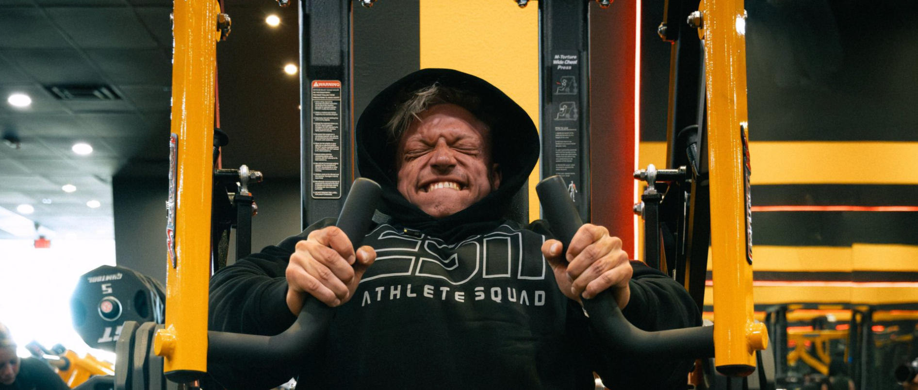 Bodybuilder Urs Kalecinski beim kontrollierten Krafttraining mit Fokus auf Time under Tension zur Förderung von Muskelaufbau und Hypertrophie im Gym