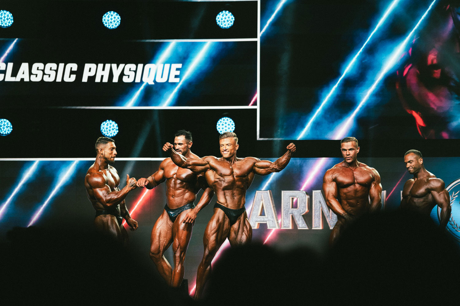 Urs Kalecinski mit anderen Bodybuildern auf der Bühne