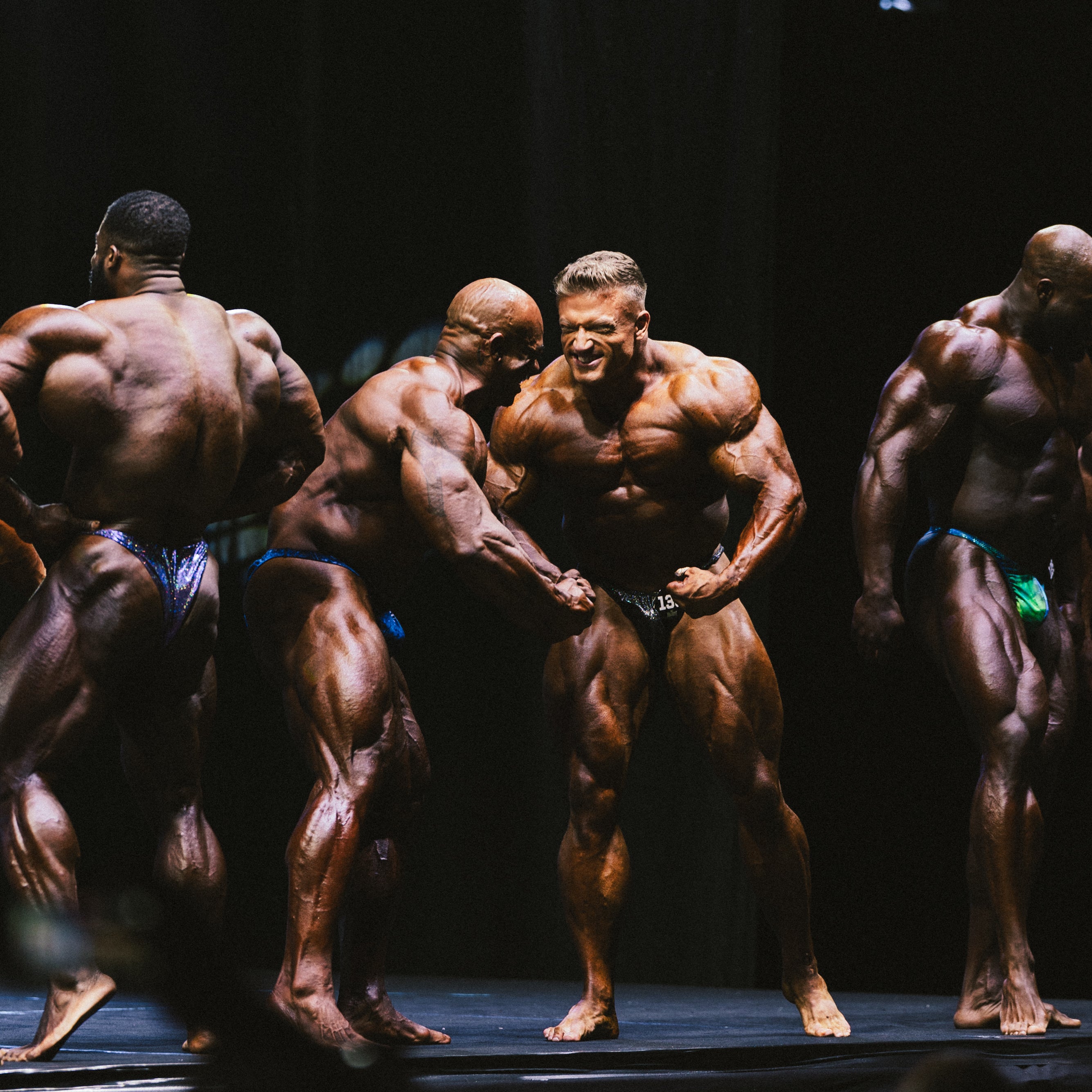 Profibodybuilder Urs Kalecinski mit Mitbewerbern auf der Bühne
